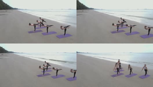 鸟瞰图的团队身体战斗群做瑜伽在一个阳光灿烂的一天在海滩上。高清在线视频素材下载