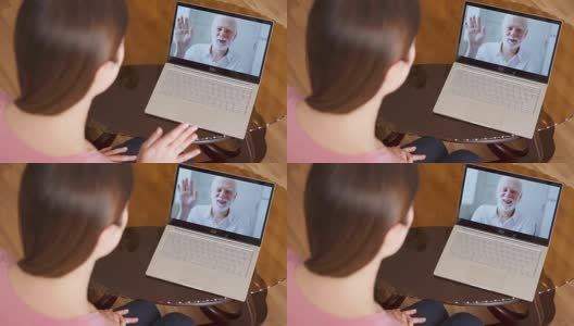 在国外留学的女儿在笔记本电脑上通过即时通讯软件和她的父亲视频聊天高清在线视频素材下载