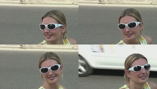 带着白色太阳镜微笑的漂亮女人在等车高清在线视频素材下载