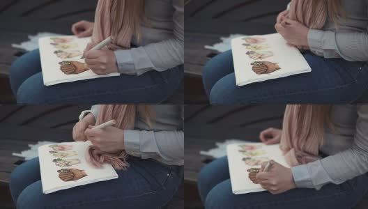 年轻的女学生正用毛笔勾勒着明亮的画面，手的特写高清在线视频素材下载