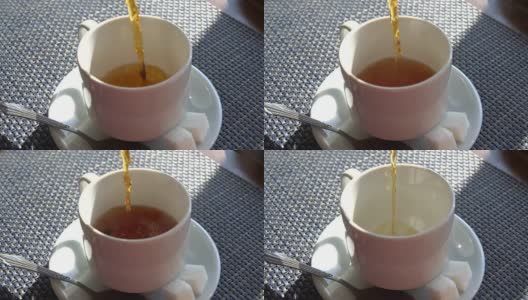用慢镜头把茶倒进杯子里。咖啡馆室内。阳光照射的表高清在线视频素材下载