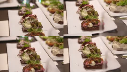 丹麦，斯堪的纳维亚式开放式三明治。美味的黑麦面包与不同种类的肉，海鲜，蔬菜浇头拍摄在慢镜头高清在线视频素材下载