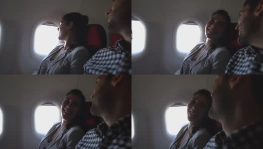 一对夫妇从飞机窗户往外看高清在线视频素材下载