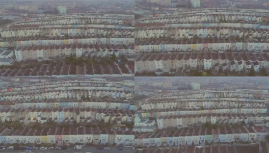 向前飞行的航拍，倾斜到水平排列的彩色梯级英国房屋，以布里斯托尔中部为背景高清在线视频素材下载