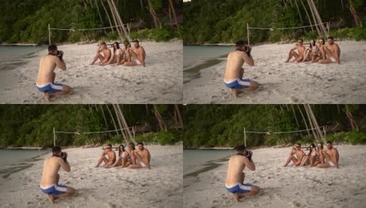 摄影师正在拍朋友们在海滩上玩耍的照片高清在线视频素材下载