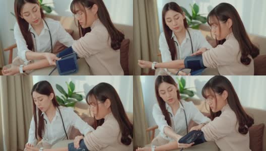 一位亚洲女医生正在给这位年轻的女病人在家测量血压。高清在线视频素材下载