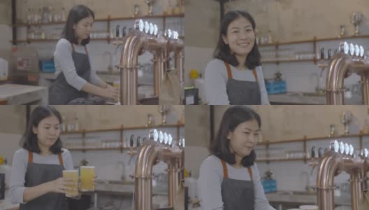 年轻的亚洲女调酒师端着一杯啤酒给顾客，微笑着看着镜头。高清在线视频素材下载