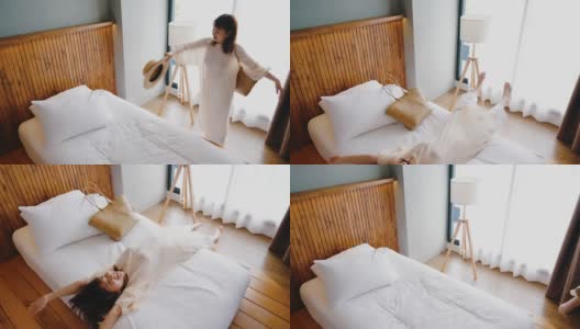 疲惫的女人享受在她的酒店房间柔软的床。高清在线视频素材下载