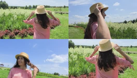 迷人的女孩在优雅的粉红色衣服愉快地站在田野的花在夏天。有自由的感觉。美丽,漂亮。大自然的力量，美丽高清在线视频素材下载