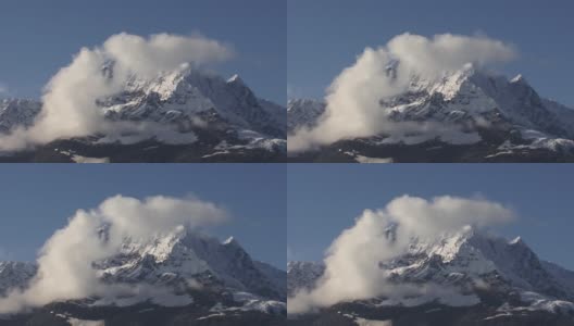 在一个阳光明媚的日子里，阿拉斯加冰川湾的一座雪山顶上的白色蓬松的云高清在线视频素材下载