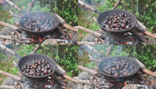用特制的钢锅在火上烤栗子和马罗尼。传统的意大利秋季美食户外烹饪。高质量的全高清镜头。软焦点高清在线视频素材下载