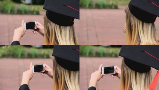 一名女毕业生用手机拍摄她的朋友，并竖起大拇指高清在线视频素材下载