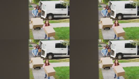 在家庭搬家的日子里，孩子帮助从货车上卸下箱子高清在线视频素材下载