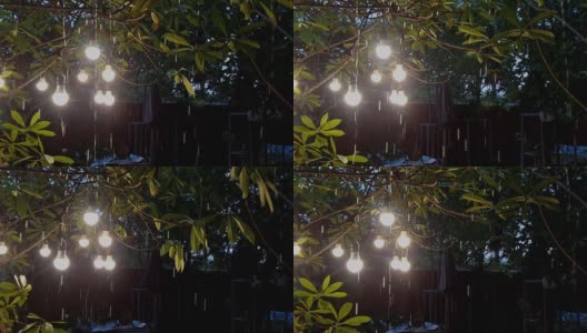 一扇窗户，雨水透过一盏灯在花园里闪耀。高清在线视频素材下载