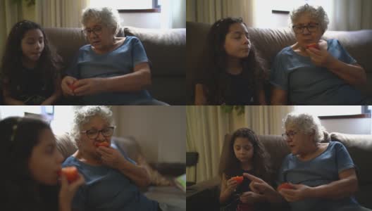 奶奶和孙女在家吃柿子高清在线视频素材下载