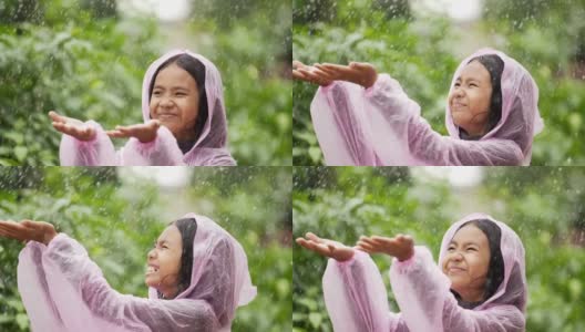 快乐的女孩穿上雨衣，伸出手高清在线视频素材下载