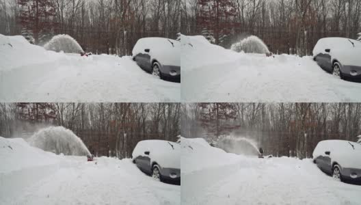 在一场冬天的暴风雪后，一名男子正在清理他被雪覆盖的汽车周围的车道。高清在线视频素材下载