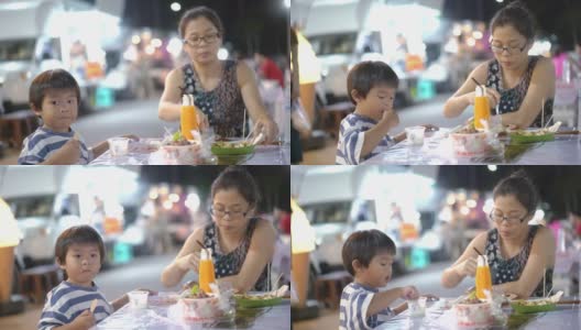 小男孩和他的妈妈在餐车区喝新鲜的橙汁高清在线视频素材下载