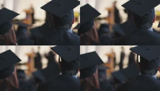在大学毕业典礼上，兴奋的学生们戴着学士帽和学士服鼓掌高清在线视频素材下载