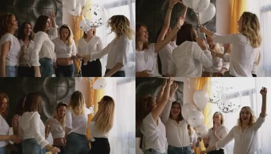 美丽的六个女人在一个女性聚会上一起出去玩。跳舞，玩气球。都穿一样的衣服，牛仔裤和白衬衫。在室内。快乐,无忧无虑高清在线视频素材下载