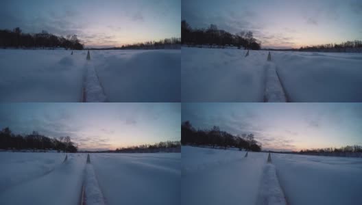 冬季健康生活理念。Cross сountry在多雪的冬日滑雪，冬季日出清晨在冰河滩上，越野滑雪，滑雪者在轨道上，大雪落在轨道上。老式越野滑雪板上的移动摄像机。第一个人高清在线视频素材下载