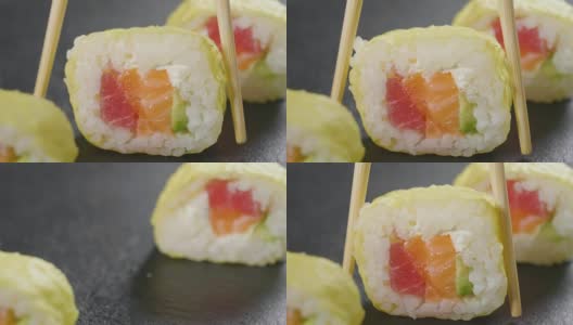寿司，生鱼片，浦城和夜拍的微距镜头。典型的日本菜，包括米饭、鲑鱼或金枪鱼、虾和浸在酱油中的鱼卵。高清在线视频素材下载