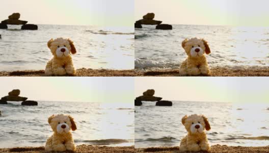 特写，玩具狗孤独地坐在沙滩上，背对着大海，日出或日落高清在线视频素材下载