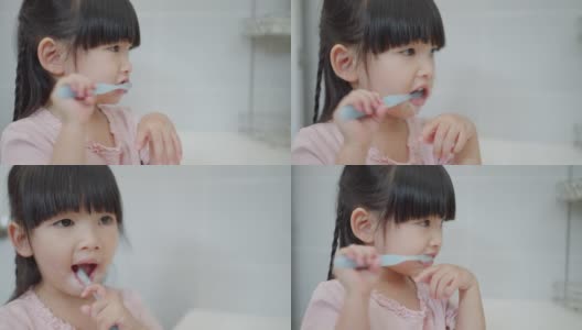 亚洲可爱的小女孩或小孩在浴室用牙刷刷牙。口腔卫生保健理念。高清在线视频素材下载