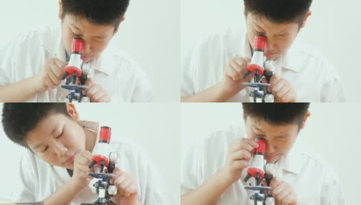 亚洲男生穿着实验服在科学课上使用显微镜，教育理念。高清在线视频素材下载