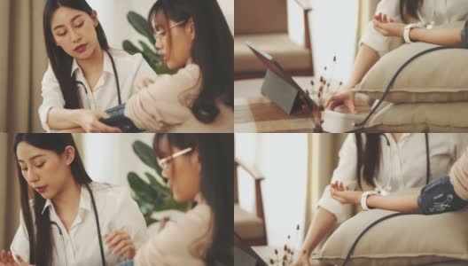 女性保健工作者在一次家庭健康探访期间为一名少女量血压高清在线视频素材下载