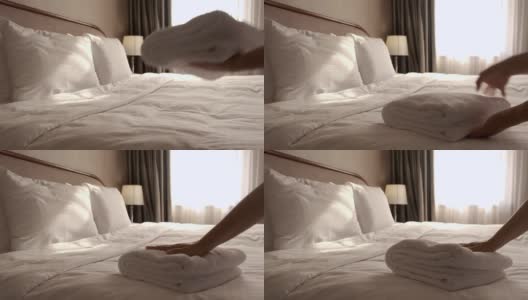 一个女人在床单上放了一条新毛巾。房间服务。高清在线视频素材下载