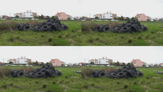 一堆旧橡胶轮胎在一片绿地上。堆放废弃的车轮高清在线视频素材下载