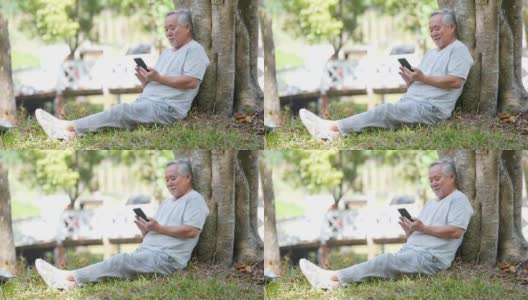 亚洲老年人在公园玩手机游戏高清在线视频素材下载