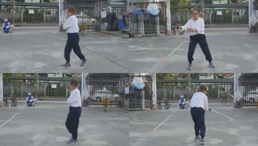 一位老妇人在停车场练习中国手扇子舞高清在线视频素材下载