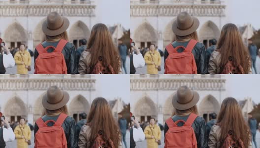 两个旅行的女人背着背包走在巴黎圣母院附近，著名的大教堂，法国巴黎高清在线视频素材下载