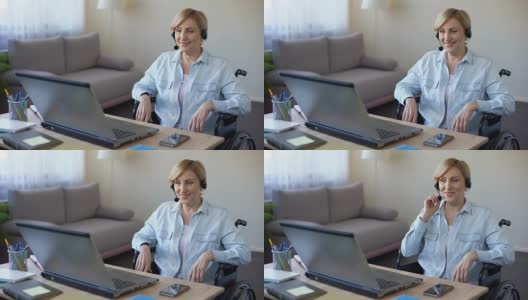 坐在轮椅上用笔记本电脑工作的资深女商人，在线视频会议高清在线视频素材下载