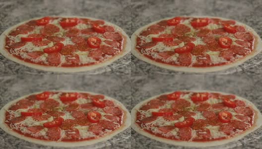 在披萨上倒橄榄油。意大利腊肠、胡椒、奶酪和橄榄油的披萨高清在线视频素材下载