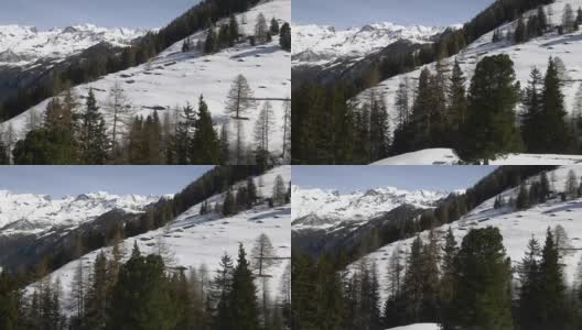 冬季无人机建立雪山下的森林森林山谷。雪山在户外自然。一边飞行。旅行探索阿尔卑斯山，4k俯视图视频高清在线视频素材下载