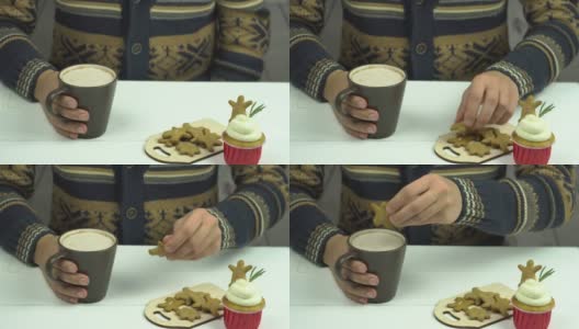 男人的手把姜饼蘸可可。桌子上有很多姜饼人和一个小蛋糕高清在线视频素材下载