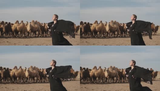 美丽的女子民族黑衣服，阿拉伯长袍走草原骆驼，沙漠，缓慢高清在线视频素材下载