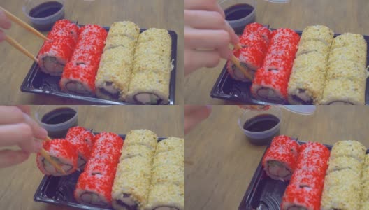 特写镜头。有人用筷子、卷和酱油吃寿司高清在线视频素材下载