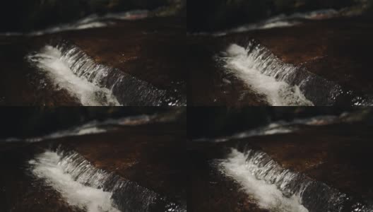 印度穆纳尔的一条河流在森林中间的一块岩石地上流淌高清在线视频素材下载