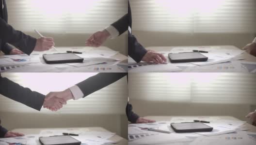 在数字平板电脑上签署合同和握手时，女商人和商人的慢动作手高清在线视频素材下载