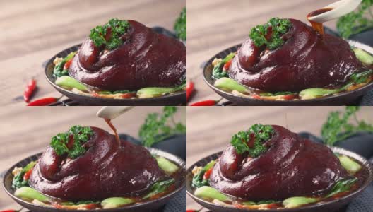 用勺子将香喷喷的酱油倒在盘子里的台湾红烧猪腿肉上。高清在线视频素材下载