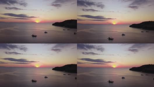 在印度尼西亚巴厘岛附近的弗洛雷斯岛，海上日落的空中美景和船只的剪影。拍摄分辨率为4k高清在线视频素材下载