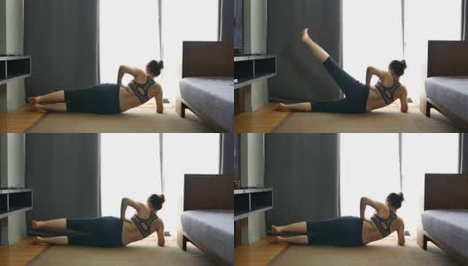 年轻女子在家客厅练瑜伽高清在线视频素材下载