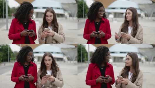 两个女人在街上走着，其中一个正在看手机上的照片高清在线视频素材下载