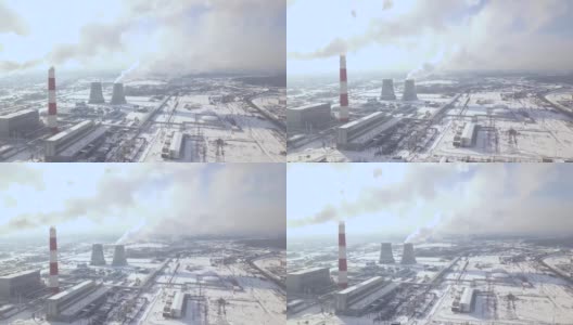 工业工厂和冒烟的烟囱在冬季城市无人机视图。从发电厂鸟瞰图上看工业管道排放的烟雾。从上面看冒烟的锅炉管道高清在线视频素材下载