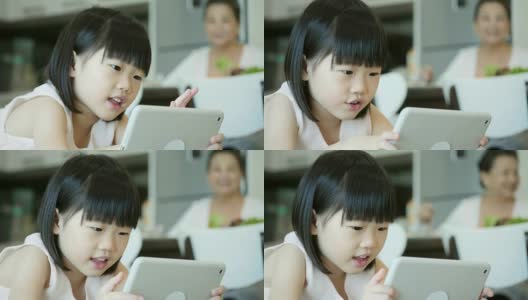 小女孩在平板电脑上玩电子游戏高清在线视频素材下载