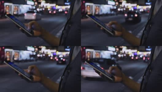 近距离观察女人的手，在她的智能手机上写信息与汽车灯光背景。高清在线视频素材下载